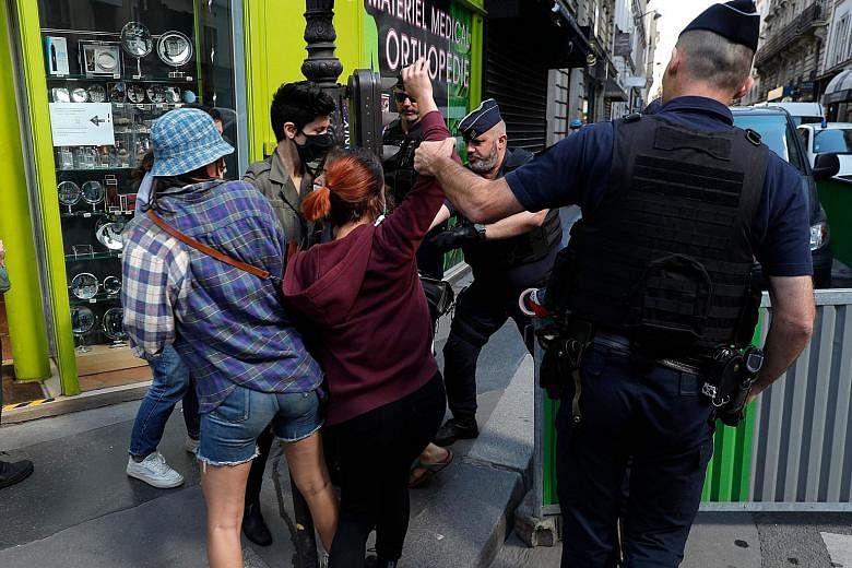 Riot police in Paris blocking feminist protesters demonstrating yesterday against the nomination of Mr Gerald Darmanin as French Interior Minister. France is beefing up three ministries and focusing on tackling the pandemic's social and economic fall