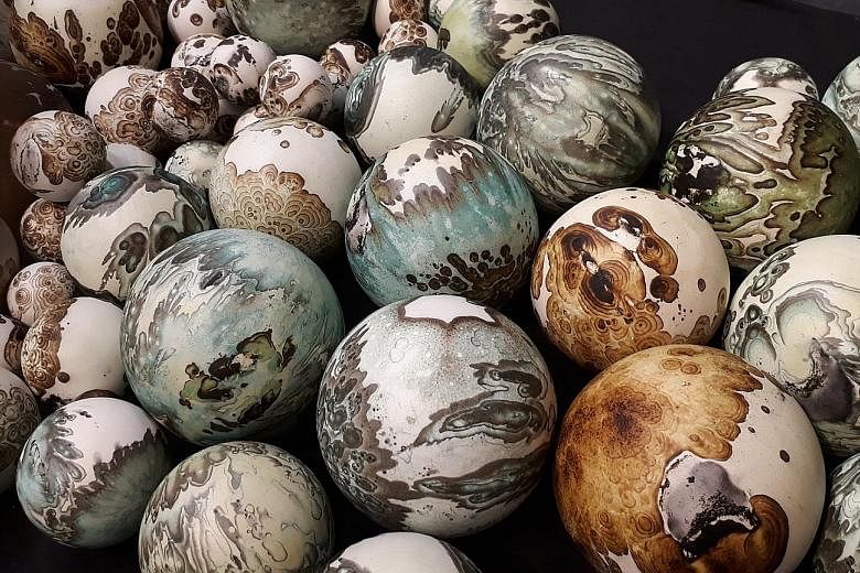 Ceramic artist Steven Low (above) has created a set of clay globes (left) in the style of his Planet series. The colourful spheres resemble miniature Earths.