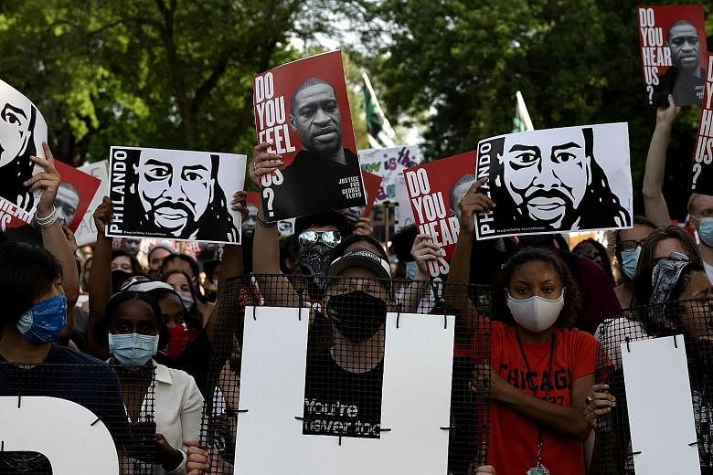Demonstrators with banners bearing the likenesses of Mr Philando Castile and Mr George Floyd during a protest march in Minnesota on Monday, the fourth-year anniversary of Mr Castile's death. The African American was shot and killed during a traffic s