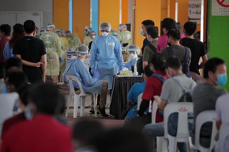 Essential workers waiting to get screened for Covid-19 at the regional screening centre in Marina Bay last month. As part of Ministry of Health's expanded testing regime, the 13-year-old Jurong West Secondary student was swabbed, and tested positive.
