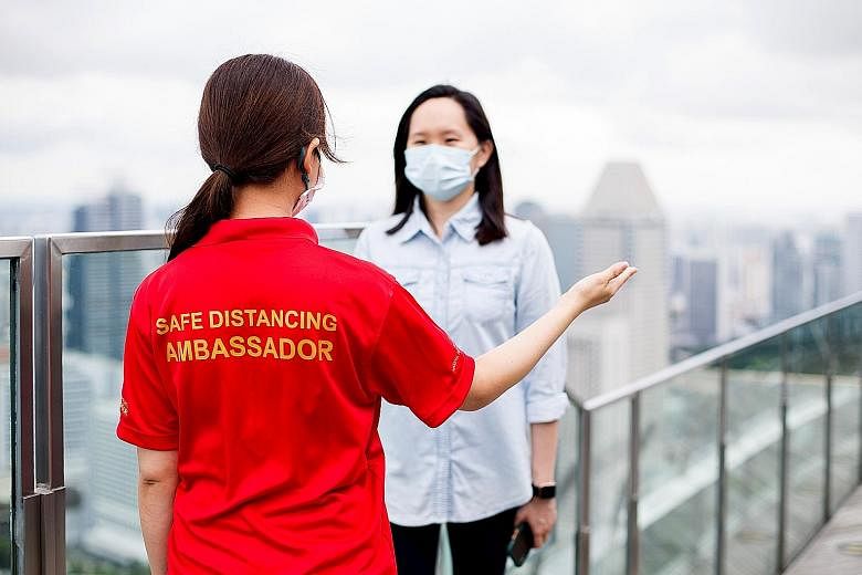 A safe distancing ambassador at the Sands SkyPark Observation Deck, one of around 800 staff members at Marina Bay Sands who have been trained to remind guests of safe distancing measures.