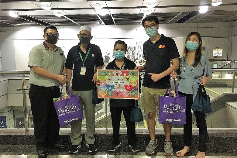 Be Kind SG founder Sherry Soon (right) and volunteer Matthew Kong (beside her) presenting care packs to some station staff and cleaners at Clarke Quay MRT station on Saturday.