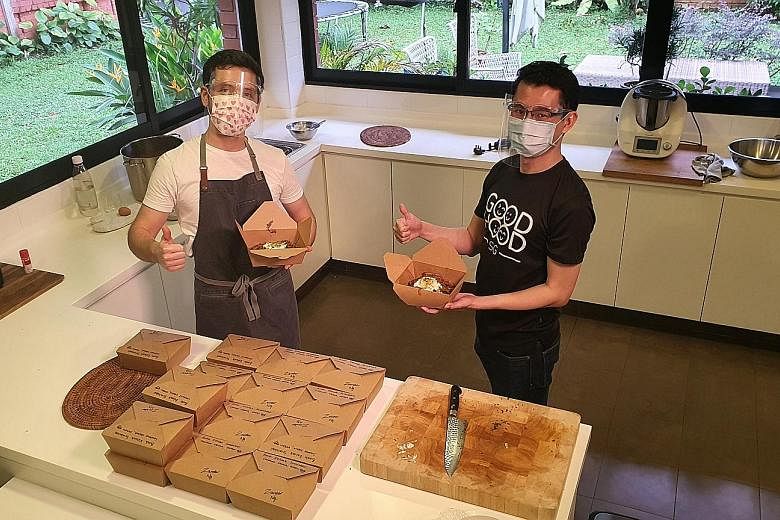 MasterChef Singapore winner Zander Ng (left) and GoodHood.SG founder Nigel Teo, with meals prepared by Mr Ng under the #KindCooks initiative, which connects neighbours who cook with those in need of meals. The initiative has seen 40 volunteers provid