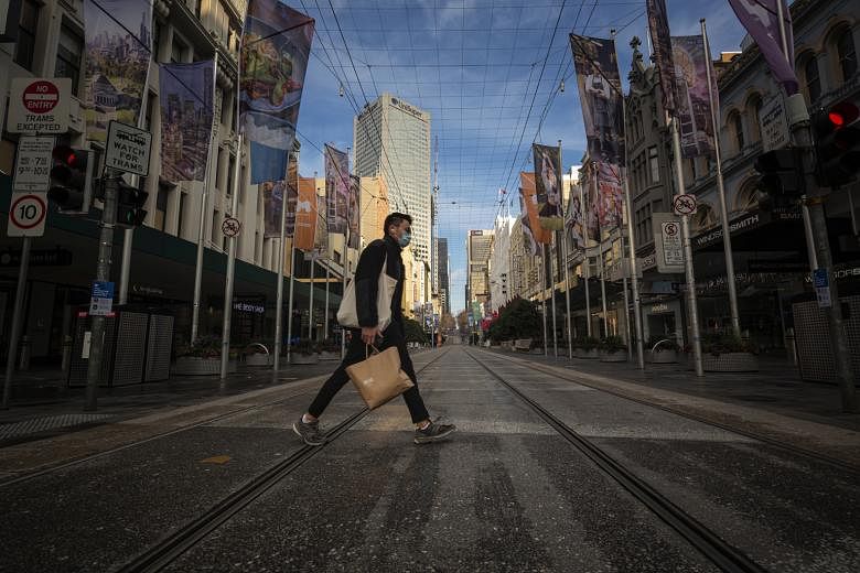 (Above) A main street in Melbourne's central business district yesterday. Daily occupancy of city offices in Melbourne (left) reportedly plunged to as low as 5 per cent late last month, according to a report in the Australian Financial Review. PHOTOS
