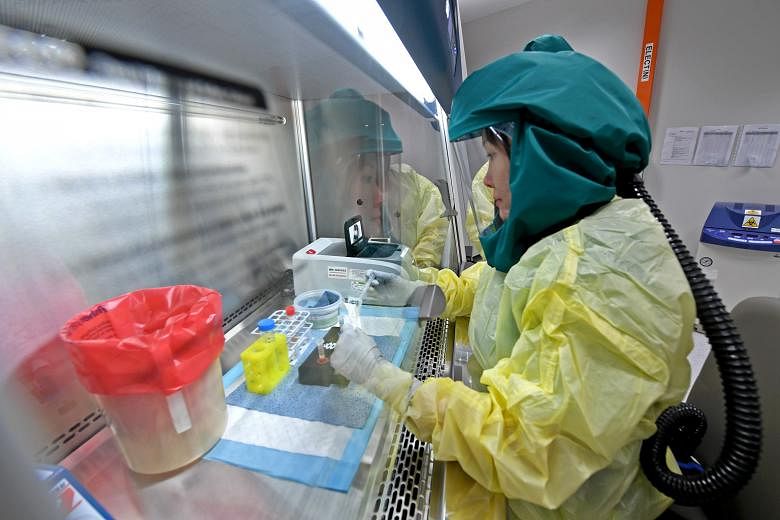 Lab technicians testing for respiratory pathogens at the National Public Health laboratory at Singapore's National Centre for Infectious Diseases. The centre has said it is studying whether the coronavirus is naturally airborne and infectious in such