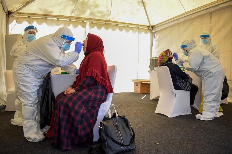 Health workers conducting swab tests on civilians residing in the compounds of the Indonesian Army Officer Candidate School in Bandung, West Java province, on Saturday.