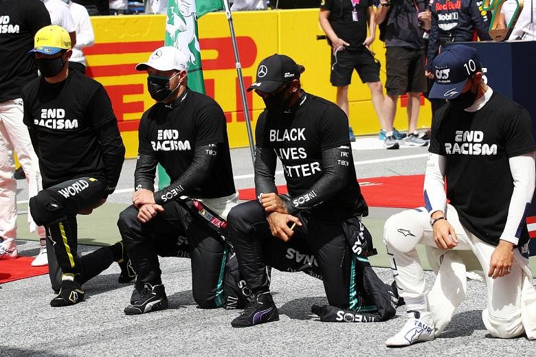 Mercedes' Lewis Hamilton and other drivers, wearing anti-racism shirts, kneeling before the Steiermark race in Spielberg on Sunday. PHOTO: REUTERS