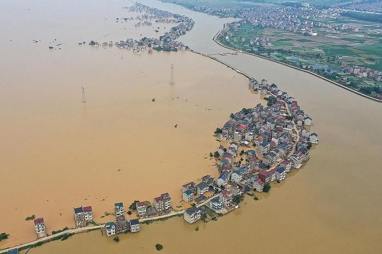 An aerial view of submerged streets and inundated buildings after a dam was breached due to flooding in Jiujiang, China's central Jiangxi province, on Monday. 