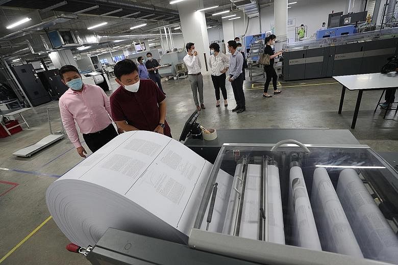 Senior Minister of State for Trade and Industry Chee Hong Tat checking out the printing process at Markono Content Solutions' facility in Pioneer yesterday as the company's managing director Edwin Ng looked on. ST PHOTO: TIMOTHY DAVID