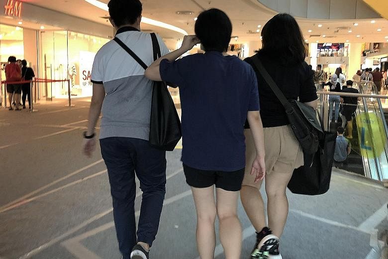 Retrenched staff from Resorts World Sentosa (RWS) carrying black bags containing a folder with their employment details and testimonials at VivoCity mall yesterday. RWS declined to specify how many staff were laid off.