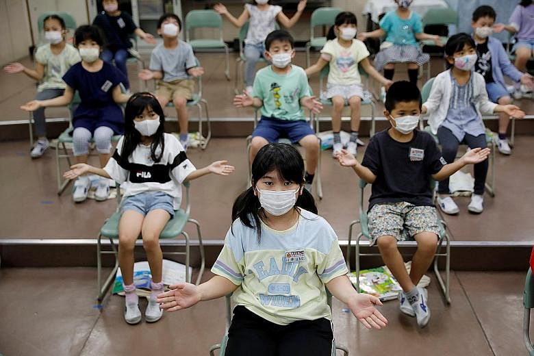 Pupils clapping along instead of singing a song during a music class at a school in Funabashi, east of Tokyo, yesterday. Tokyo reported a daily high of 286 new cases yesterday. The uptick has complicated a multibillion-dollar plan to boost domestic t