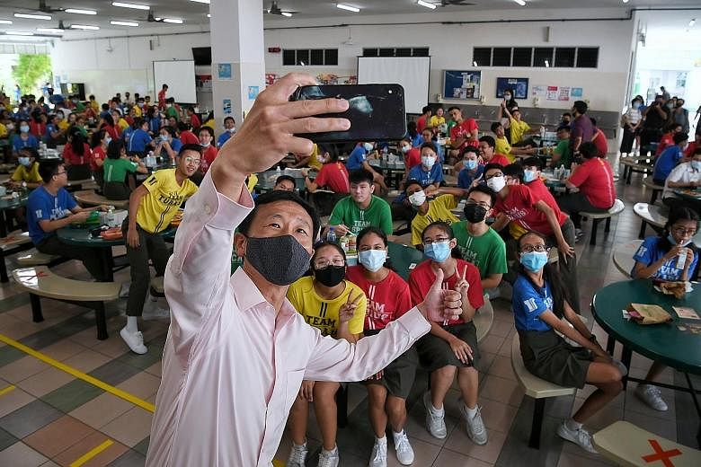 Right: A teacher conducting a character and citizenship education class with Secondary 3 students at Tampines Secondary School. Far right: Education Minister Ong Ye Kung taking a wefie with Secondary 4 students at Tampines Secondary yesterday. Mr Ong