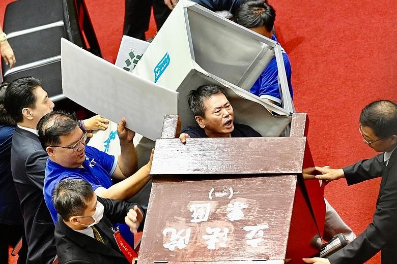 Taiwan's opposition party lawmakers trying to remove a voting booth in Parliament yesterday to block the ruling party's lawmakers from casting ballots for the nomination of President Tsai Ing-wen's senior aide, Ms Chen Chu, to a top government watchd