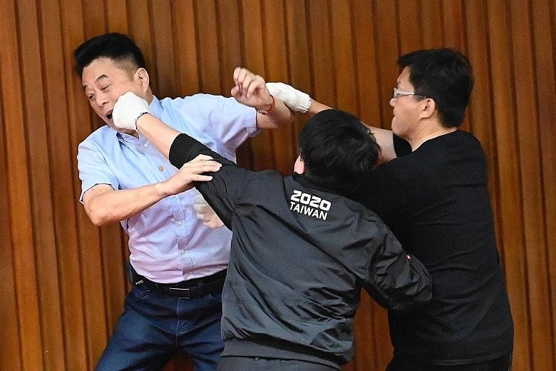 Lawmakers going at one another yesterday. Several KMT lawmakers knocked down voting booths inside Parliament's main chamber to block DPP legislators from casting ballots over the nomination. Lawmakers from both the ruling Democratic Progressive Party