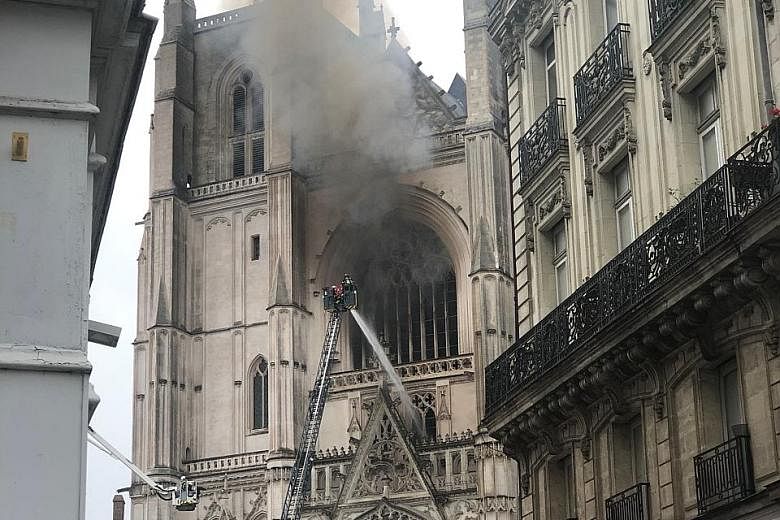 Firefighters battling the blaze at the 15-century cathedral in the western French city of Nantes yesterday. The fire engulfed the interior in flames, destroyed the grand organ and blew out several stained-glass windows.