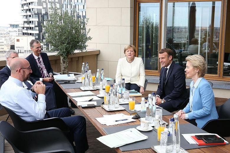 German Chancellor Angela Merkel in discussions with French President Emmanuel Macron; president of the European Commission Ursula von der Leyen; and European Council president Charles Michel (left, in white shirt), in Brussels yesterday to prepare a 