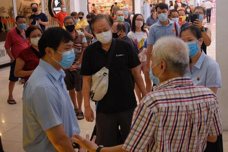 Associate Professor Jamus Lim and Ms He Ting Ru of the Workers' Party team that won in Sengkang GRC speaking to a resident on a thank-you walkabout at Rivervale Plaza on July 12. ST PHOTO: MARK CHEONG