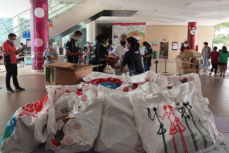 Residents observing safe distancing yesterday while collecting their National Day Parade packs at Tampines West Community Club. Yesterday was the first day that Singaporean and permanent resident households could collect the Singapore Together Pack f
