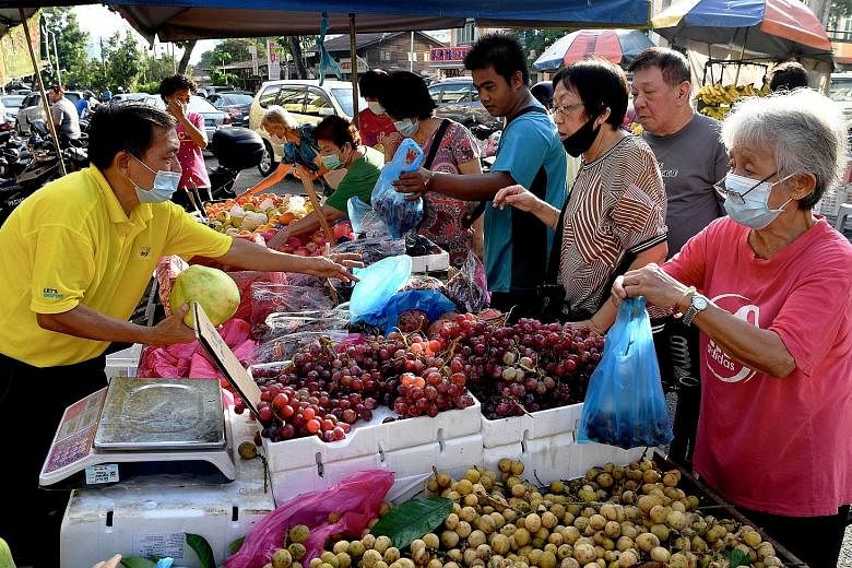 Crowds ignoring social distancing rules while buying fruits in George Town, Penang, yesterday. The number of new Covid-19 cases has been slowly edging higher in Malaysia, averaging 14 new cases daily since last Friday.