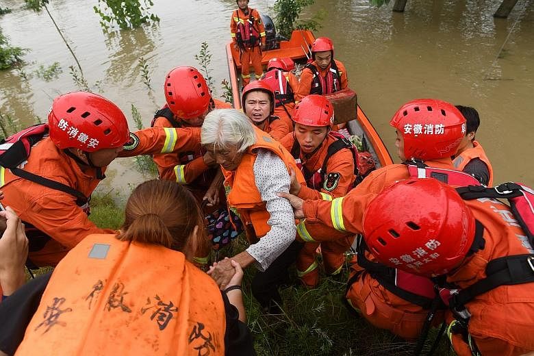 Rescue workers evacuating a flood-affected resident near the Wangjiaba dam on the Huai River in China's Anhui province on Tuesday.