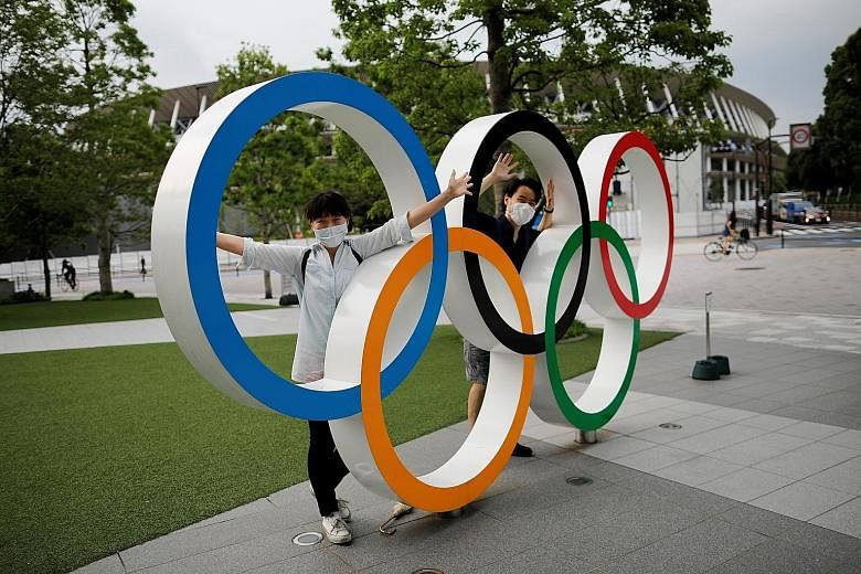 The Olympic rings outside the National Stadium in Tokyo continue to draw visitors despite the Games' postponement. A poll has revealed that under a quarter of Japanese are in favour of the city holding the Olympics in 2021.