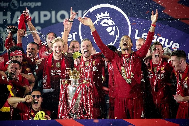 Skipper Jordan Henderson (centre) and teammates cheering with the Premier League trophy after the presentation at Anfield on Wednesday. Top: The Premier League trophy is manager Jurgen Klopp's fourth with Liverpool in a year after the Uefa Super Cup,