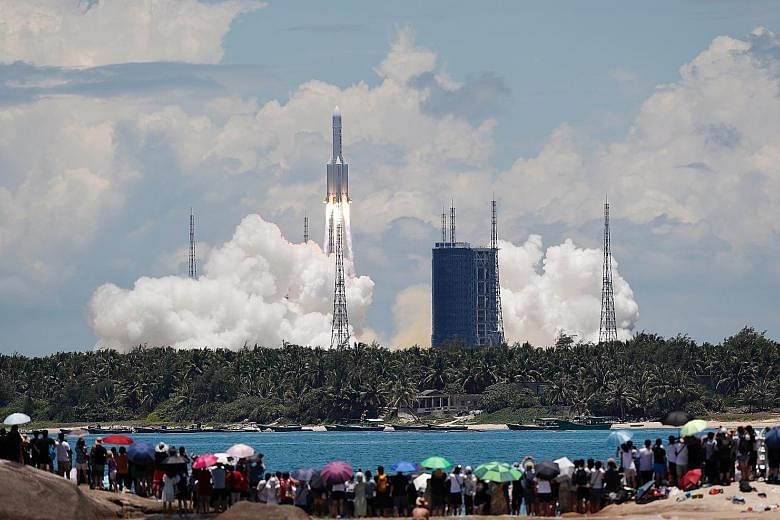 A crowd of onlookers watching from a beach as the Long March 5 Y-4 rocket, carrying the unmanned Tianwen-1 probe, blasted off on its Mars mission yesterday. This photo from China Daily shows the rocket launch at the Wenchang Space Launch Centre on Ch