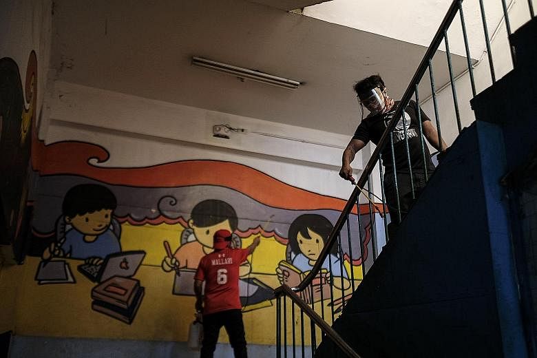 Maintenance workers in masks and face shields sanitising the Rosauro Almario Elementary School in Manila on Tuesday. While 90 per cent of public school students have re-enrolled for the 2020-2021 school year, private schools have seen a plunge in the