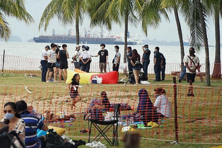 Police talking to visitors at East Coast Park (above), and a not-overly crowded Siloso Beach on Sentosa (below) yesterday. While many people were wearing masks and adhering to safe distancing measures at Singapore's beaches, there were also some who 