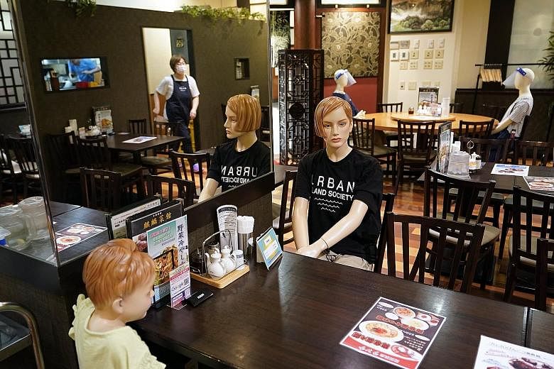 Mannequins being used to help customers maintain social distancing in a Chinese restaurant in Tokyo yesterday. Economy Minister Yasutoshi Nishimura wants businesses in Japan to aim for 70 per cent telecommuting and has also called on companies to enc