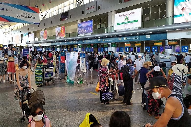 Domestic tourists in protective masks waiting to check-in for departure at Danang's airport on Sunday, as Vietnam imposed new measures to halt the spread of Covid-19. PHOTO: REUTERS