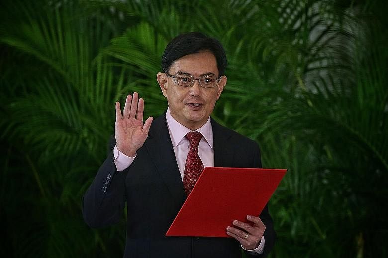 Deputy Prime Minister Heng Swee Keat taking his oath during the swearing-in ceremony at Parliament House yesterday. ST PHOTO: KEVIN LIM President Halimah Yacob presiding over the swearing-in of Prime Minister Lee Hsien Loong and his Cabinet ministers