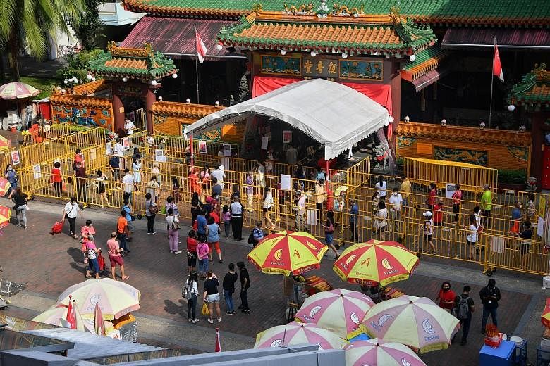 The Kwan Im Thong Hood Cho Temple reopened yesterday, four months after it closed amid the coronavirus pandemic. Devotees were seen observing safe distancing (above and far right) as they queued to enter the temple to offer their prayers. The long li