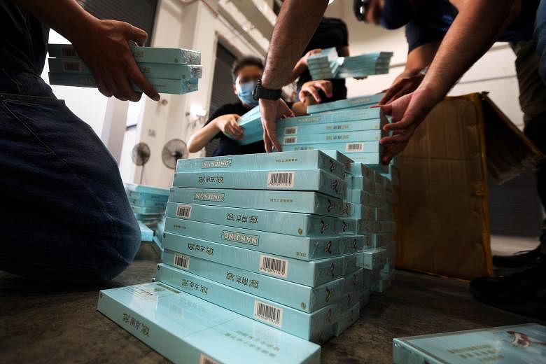 Above: Customs officers raiding a Woodlands flat last month. A Chinese national was arrested with 1,000 cartons of contraband cigarettes hidden in metal boxes. The illegal cigarettes had been declared as tea. The officers had been monitoring the ship