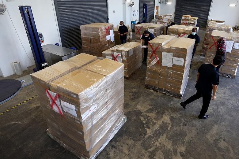 Above: Customs officers raiding a Woodlands flat last month. A Chinese national was arrested with 1,000 cartons of contraband cigarettes hidden in metal boxes. The illegal cigarettes had been declared as tea. The officers had been monitoring the ship
