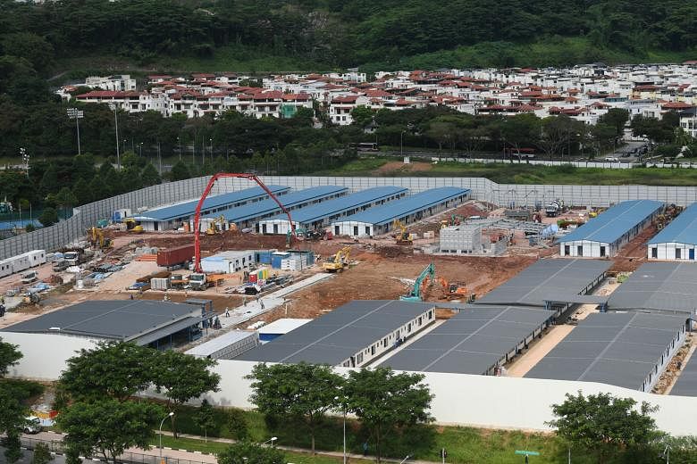 Purpose-built dorms such as the one below now house some 160,000 workers, down from 212,000 in April. Meanwhile, Quick Build Dorms like these in Choa Chu Kang (left) are part of efforts to rehouse some of the workers.