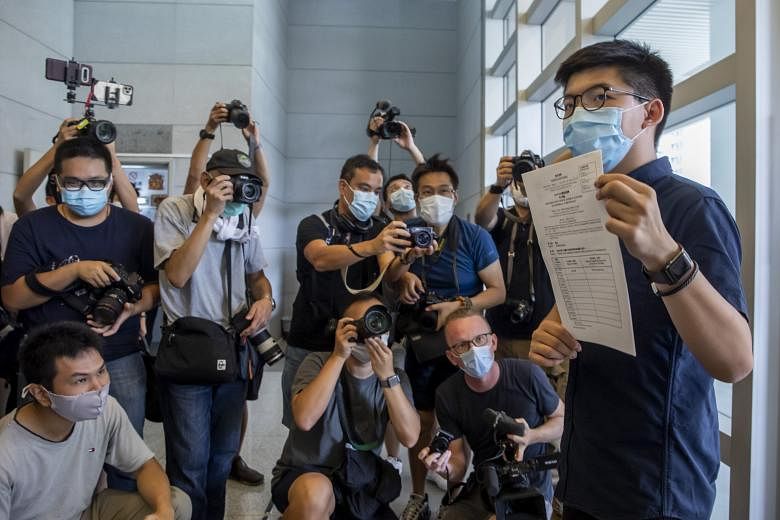 Pro-democracy activist Joshua Wong showing the media, on July 20, his application to run in this year's Legislative Council election in Hong Kong. Yesterday, reports emerged that the September vote could be postponed by a year, as the city's authorit