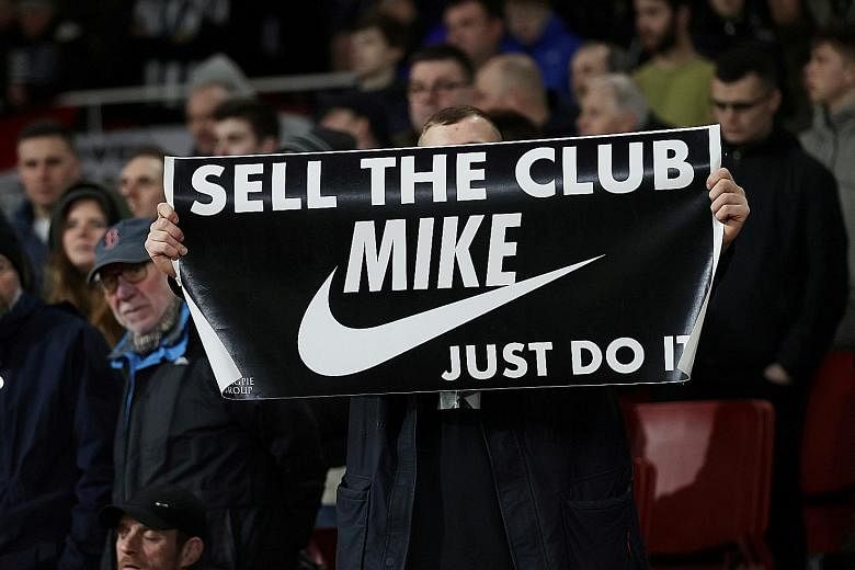 A fan displaying a banner referring to Newcastle owner Mike Ashley during the Magpies' match against Arsenal at the Emirates in February.