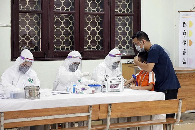 A boy who recently returned from Danang getting his blood tested at a makeshift rapid testing centre for Covid-19 in Hanoi yesterday. PHOTO: EPA-EFE