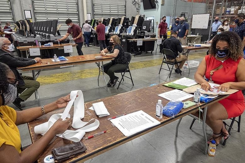 Employees conducting logic and accuracy testing of the voting equipment at the Miami Dade-County Election Department's office in Florida on Wednesday. The state will hold its primary election on Aug 18. President Donald Trump has claimed, without evi
