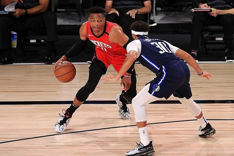 Houston Rockets' Russell Westbrook trying to dribble past Dallas Mavericks' Seth Curry in their match on Friday. Westbrook scored 31 points.