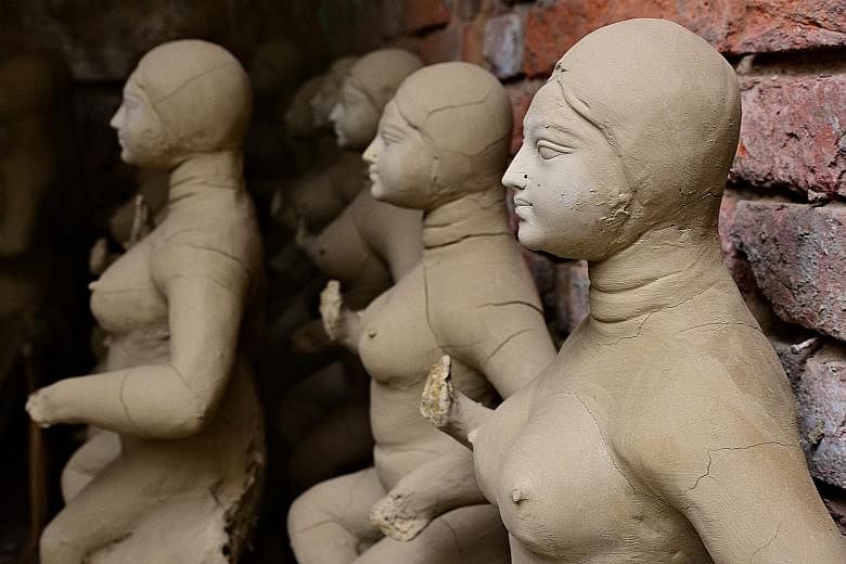An artisan chisels away at a wooden Buddhist sculpture in Hanoi. Craftsman Tarun Pal (above) is one of about 200 statue-makers in Kumortoli, a small village in Kolkata. Hindu idols (left) ready to be decorated.