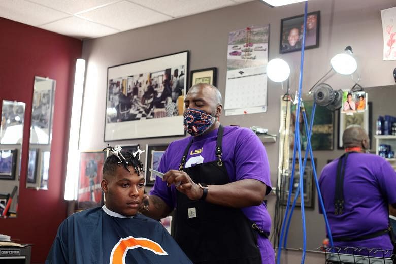 A customer having a haircut last Friday at a salon in Iowa City, Iowa, a state in the US Midwest that is seeing a resurgence in coronavirus case numbers. In the south and west of the country, several states are also reporting their highest levels of 
