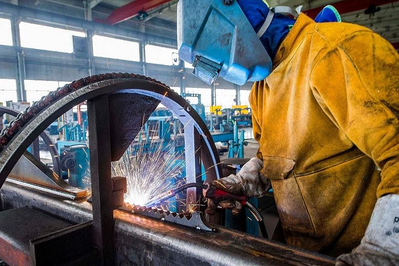 A worker welding machine parts at a factory in Weifang city, in China's eastern Shandong province. Manufacturing activity in China last month expanded at the fastest pace in nearly a decade, suggesting that the world's second-largest economy will hel