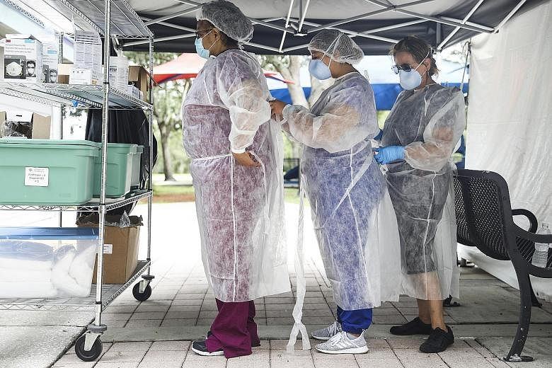 Healthcare workers securing their personal protective equipment at a coronavirus testing site in Orlando, Florida. Prevention methods, such as large-scale mask-wearing and hand washing, seem to be helping in reducing cases in Florida, Arizona and Tex
