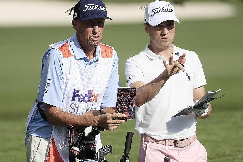 Justin Thomas and caddie Jim "Bones" Mackay discussing his second shot on the par-four final hole on Sunday. He saved par with a "pretty sick" chip for a three-shot win in the WGC event in Memphis.