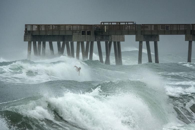 A surfer braving the high waves in Florida on Sunday as tropical storm Isaias passed near the state's shores. A hurricane watch has been issued in North and South Carolina. PHOTO: EPA-EFE