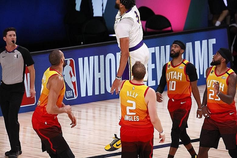 Los Angeles Lakers forward Anthony Davis dunks against Utah Jazz defenders during their NBA game at the ESPN Wide World of Sports Complex. Davis led with a game-high 42 points as the Lakers beat their rivals 116-108 to secure the top seeding.