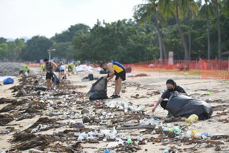 Volunteers picking up trash at East Coast Park last Friday. The National Environment Agency says there has been an almost 90 per cent increase in the amount of flotsam collected from East Coast Park beaches during the south-west monsoon season, compa