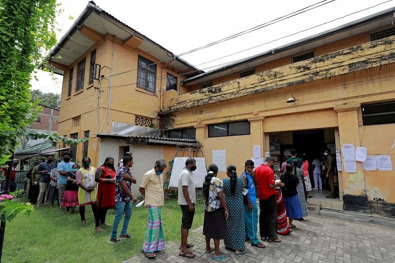 People waiting to cast their vote at a polling station during Sri Lanka's parliamentary election in Colombo yesterday. President Gotabaya Rajapaksa is seeking a two-thirds majority for his party in Parliament to enable constitutional reforms, so he c
